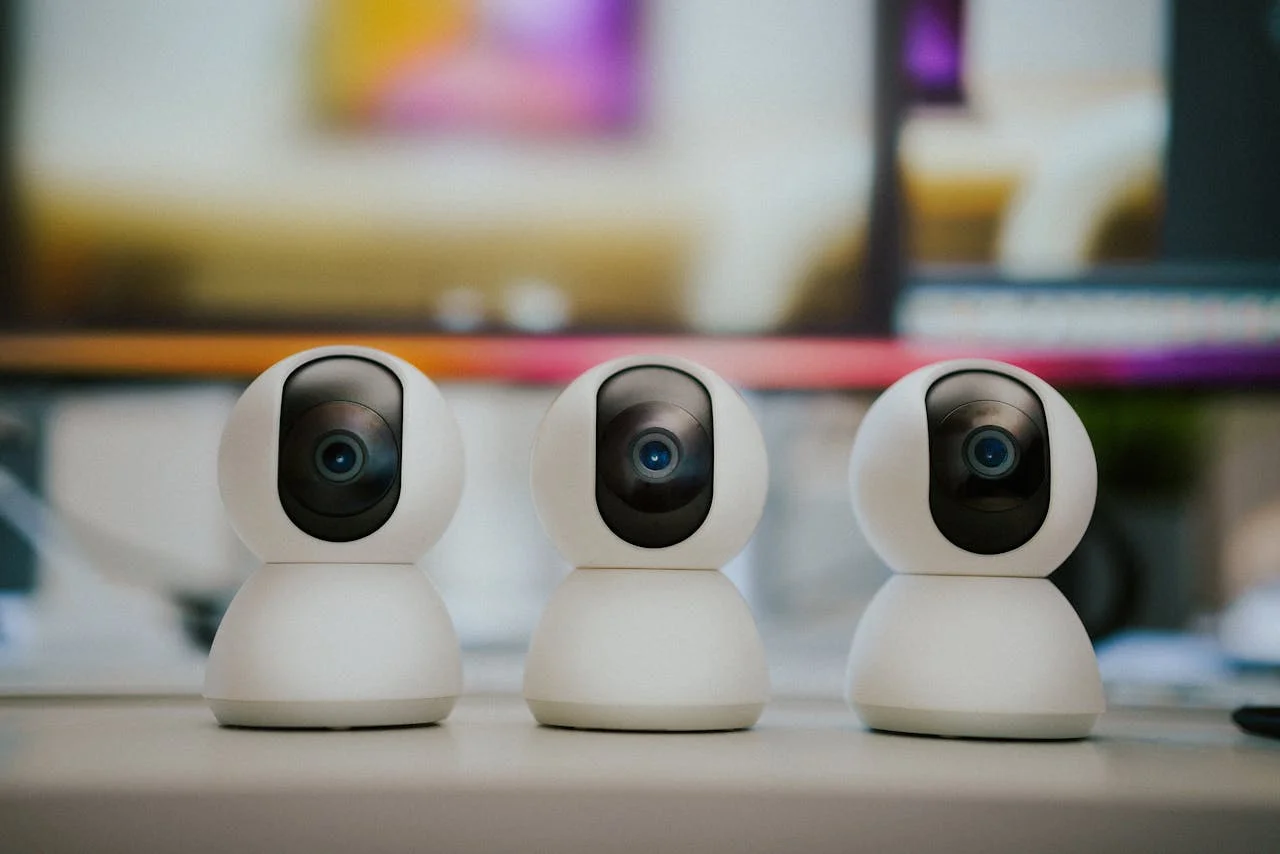 pexels-photo-28117882 Webcam security camera. Smart home monitoring equipment on home office table.